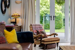 Country cottage seating area with French doors opening to garden