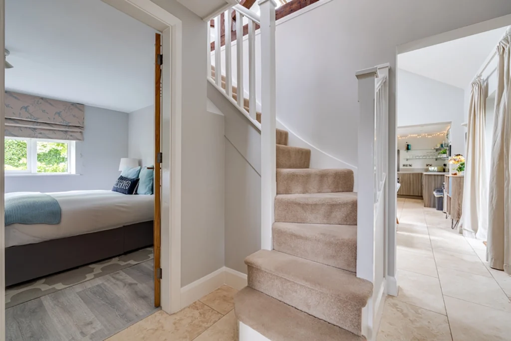 Exposed beam staircase and landing within barn conversion