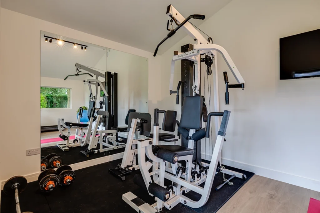 Timber frame garden room home gym with mirrored wall and gym equipment