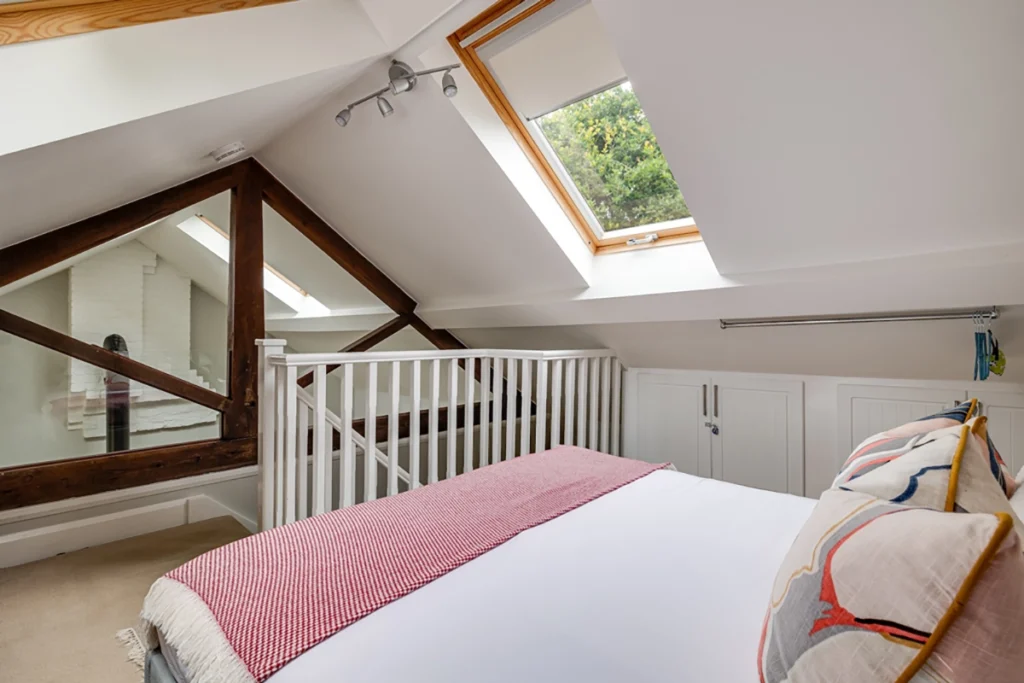 Vaulted bedroom with skylights in cottage conversion