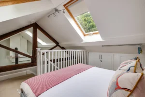 Vaulted bedroom with skylights in cottage conversion