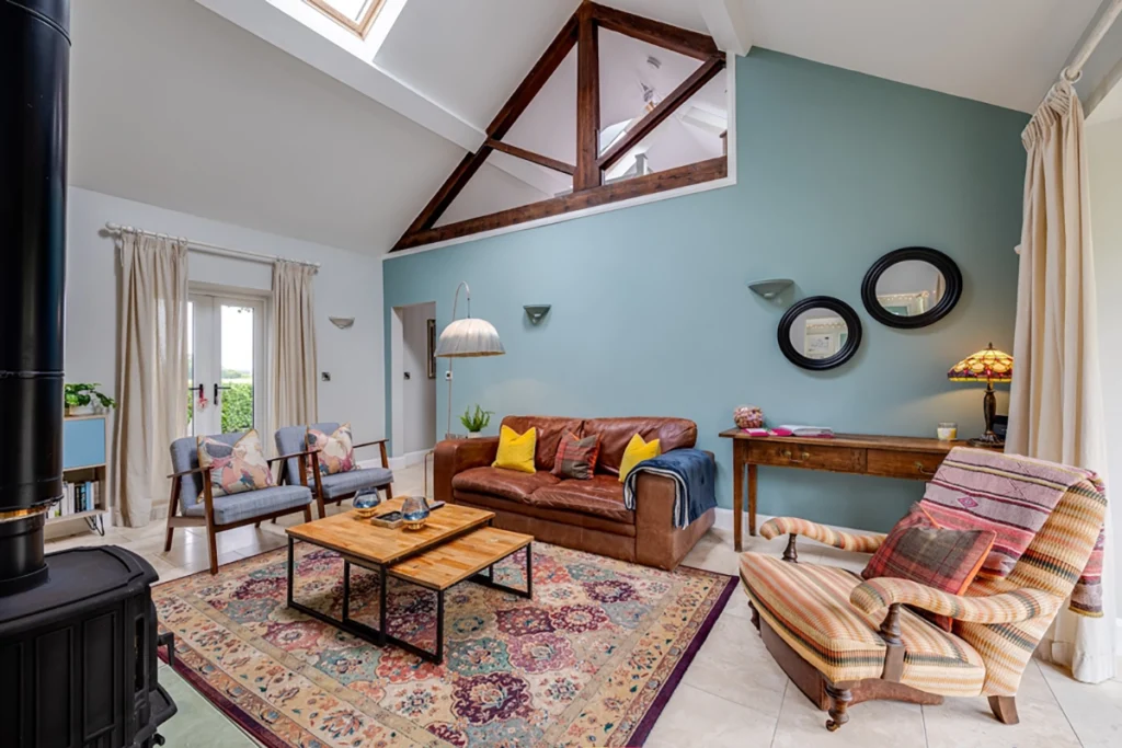 Living room with vaulted ceiling and exposed timber beams in barn conversion