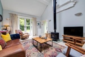 Barn conversion lounge with wood burning stove and double-height ceiling